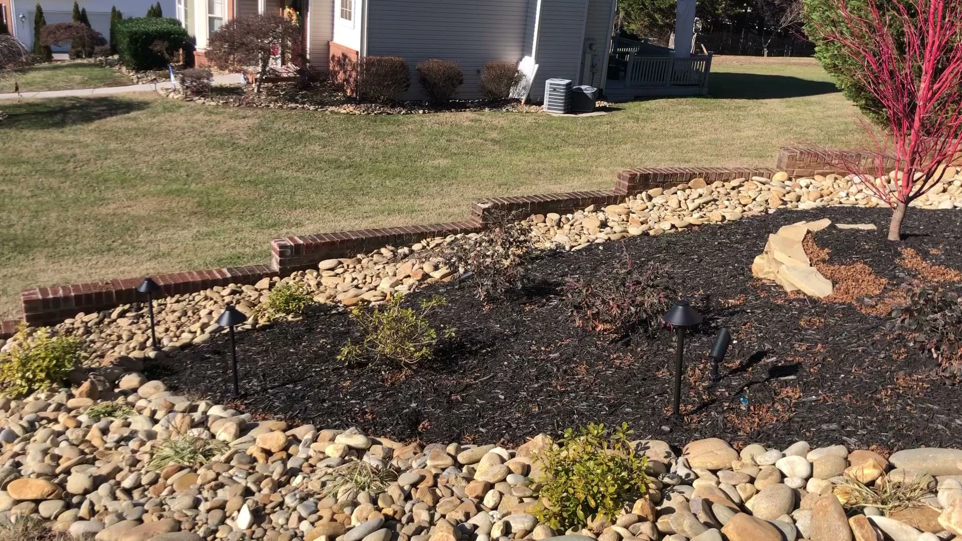 Mulch bed with a river rock border and landscape lights