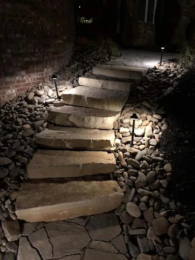 Stone walkway with outdoor path lighting for safety and curb appeal